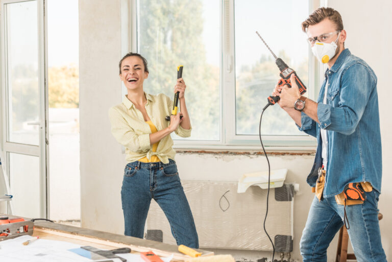 Happy homeowners with tools, demonstrating home maintenance and safety.