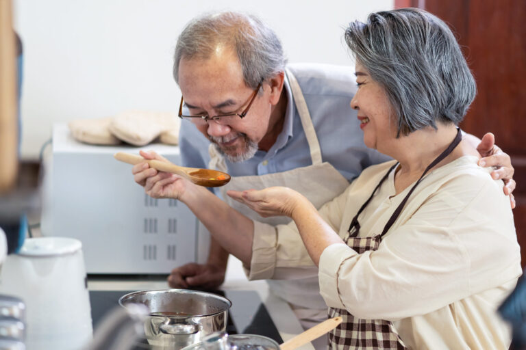 Senior couple cooking together in kitchen, lifestyle advice for seniors.