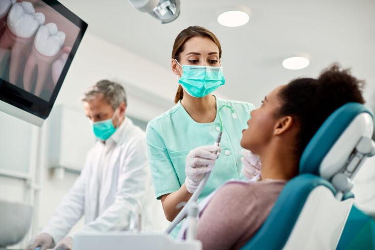 Nurse preparing patient for dental procedure, demonstrating dental care safety protocols.