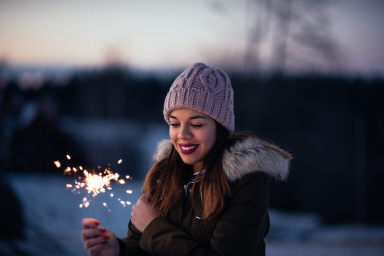 Woman smiling and holding sparklers, revitalizing life with joyful moments.